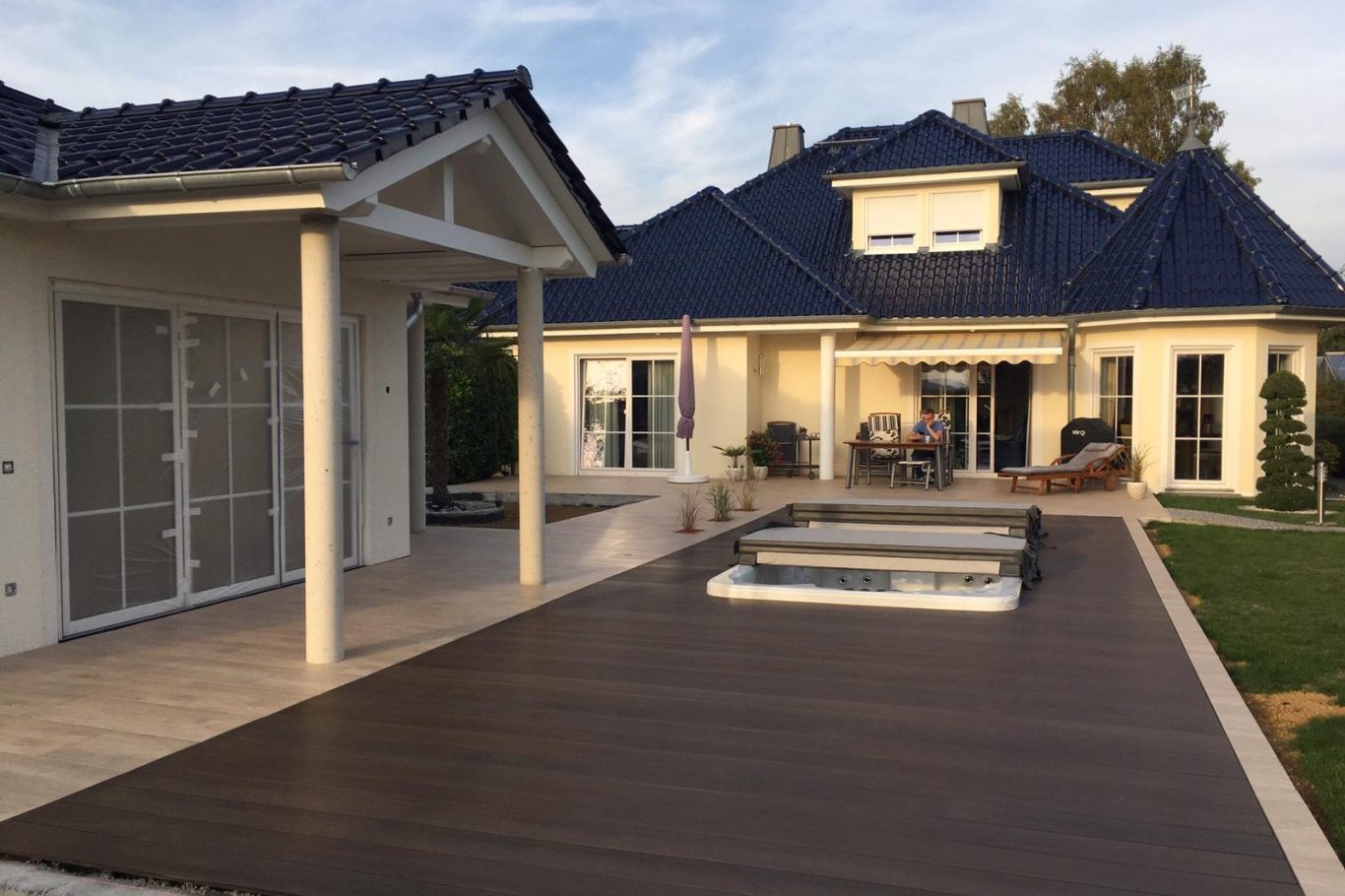 Ein modernes Haus mit Terrasse, Pool und gepflegtem Garten.